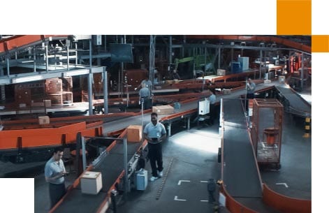 Colleagues monitor goods as they travel on conveyor belts
                                    in a large distribution warehouse